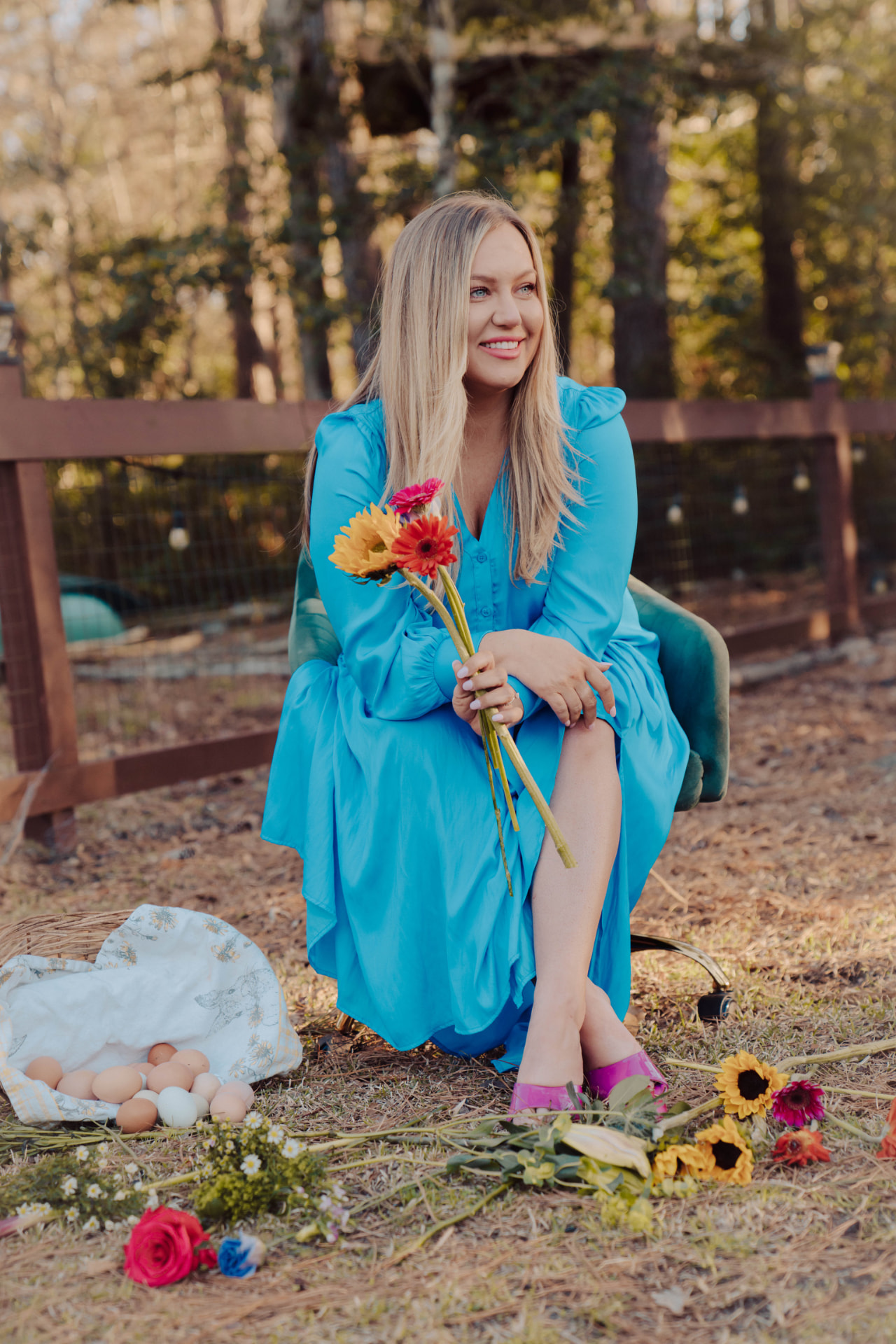 Jen Benford smiling, holding flowers outdoors